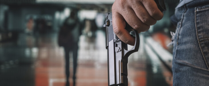 9mm pistol gun holding in hands of shooter with blurred background, concept for security, bodyguard, gangster, mafias, robbery and property protection. armed attack