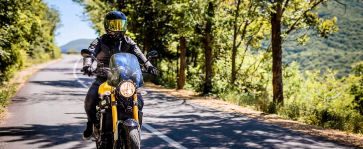 Biker with full safety gear enjoys ride on country road