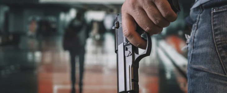9mm pistol gun holding in hands of shooter with blurred background, concept for security, bodyguard, gangster, mafias, robbery and property protection. armed attack